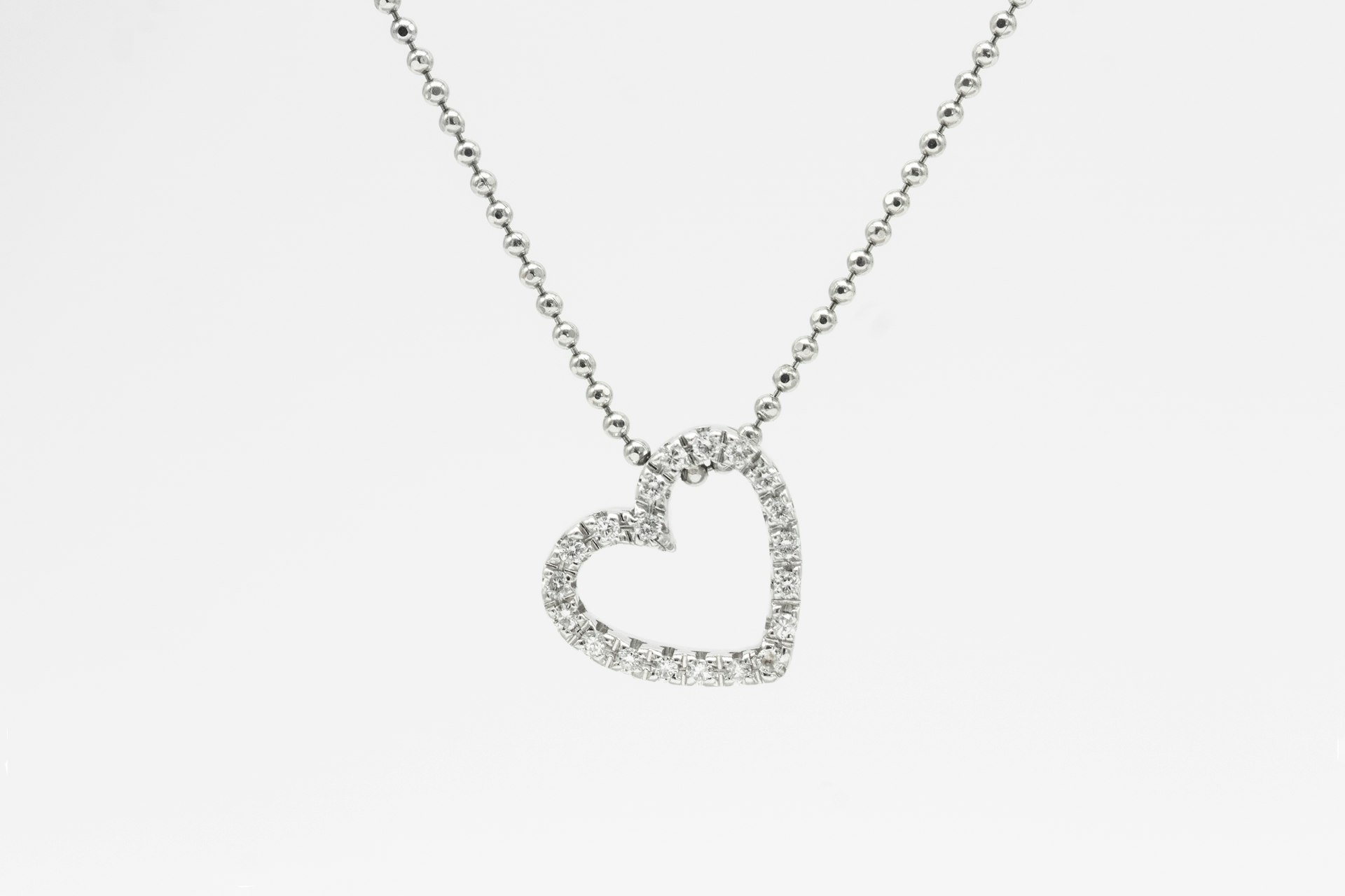 silver heart pendant necklace on white background